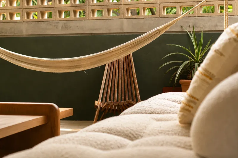 Terraza con hamaca, silla de madera y sofá